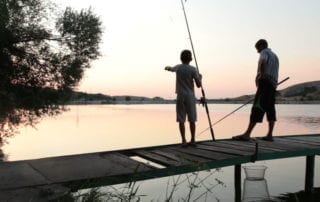 kids fishing off a lake dock